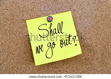 Written text Shall We Go Out ? over yellow paper note pinned on cork board