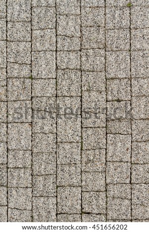 The surface paving walkway lined with natural stone. Road pedestrian overhead view. The pattern of the pieces of stone on the sidewalk path.