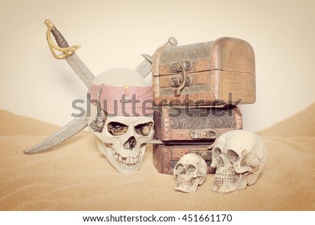 skull and swords pirate of the Caribbean with Old wooden chest on the brown fabric.