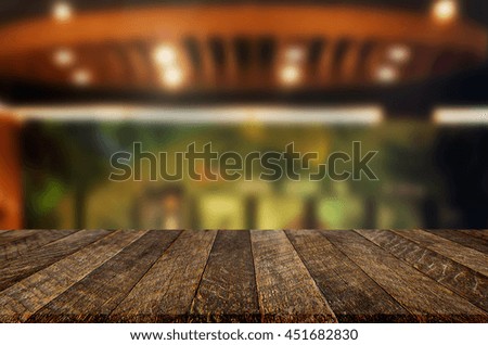 Selected focus empty brown wooden table and Coffee shop restaurant blur background with bokeh image. for your photomontage or product display