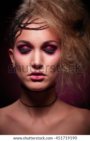 Studio portrait of woman in halloween makeup, black background.