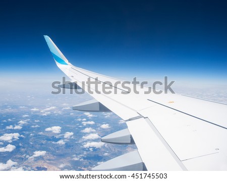 Wing of a airplane with winglet over the clouds Royalty-Free Stock Photo #451745503