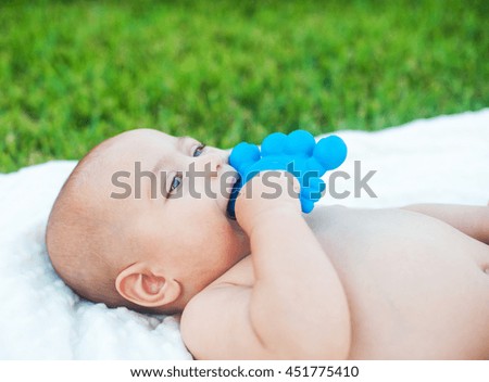 The little boy chewing on a rubber toy