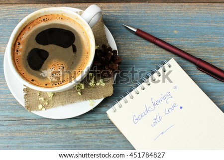 Good morning message theme:surprise for love person with cup of fresh tasty coffee decorated with natural piny cone and dry petals of hydrangea and notebook with inscription