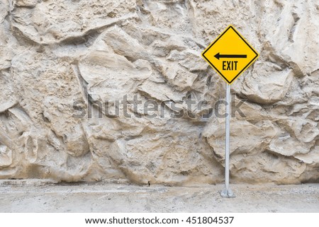 Exit sign pole with rocky wall background