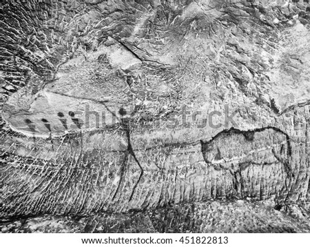 Buffalo hunting. Paint of human hunting on sandstone wall, prehistoric picture. Black carbon abstract children art in sandstone cave