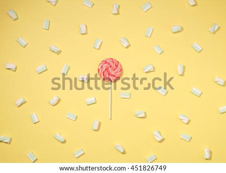 Sweet marshmallows minimalism set with red lollipop on pastel straw yellow background