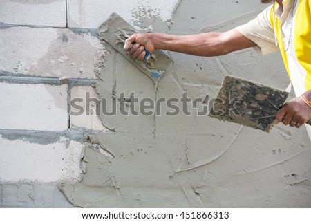 Mason plastering the concrete to build wall, Construction under  building with mason plastering concrete to brick wall Royalty-Free Stock Photo #451866313