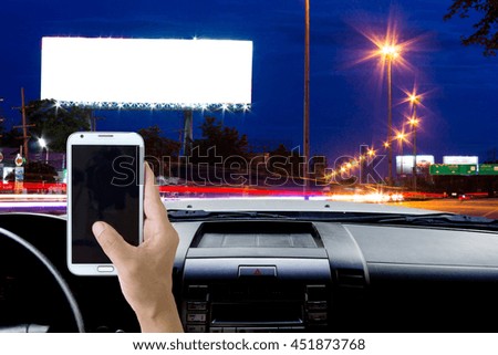 Man use mobile phone in the car, blur image of the road at night as background.