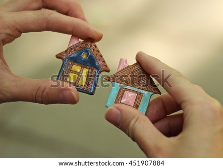 toy ceramic houses in hand 

