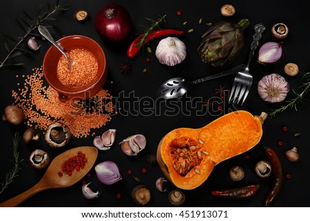 Raw vegetables and kitchen utensils on a black background. Artistic composition