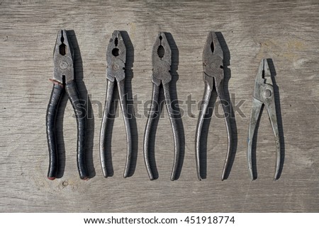 Old rusty pliers on wooden background