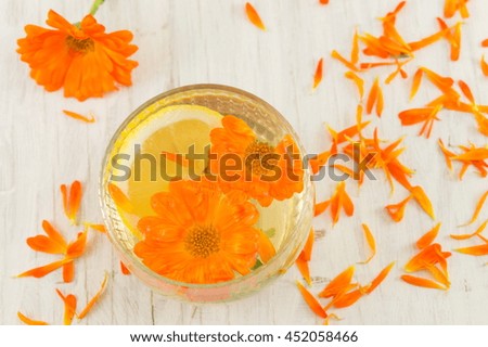 marigold flower herbal tea with lemon slices in a glass