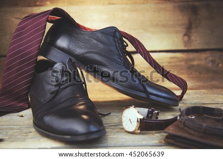 tie, shoes and watch on wooden table