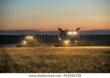 Combine harvester working on a wheat crop at night Royalty-Free Stock Photo #452066728