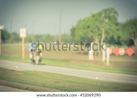 Blurred abstract motion background group of people riding bicycle near city park in Houston, Texas, US. Blurred cycling and outdoor exercise in park. Healthy lifestyle in summer concept.Vintage filter