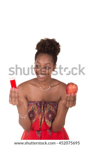 A young woman choosing between pills and an apple
