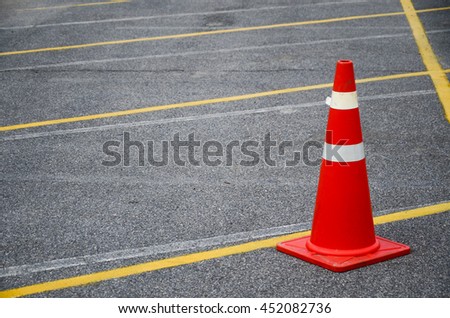orange trafic cone on the parking lot, safety cone, rubber cone