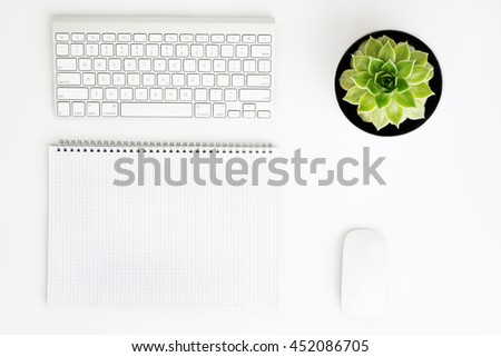 White office desk table with wireless aluminum keyboard, paper, mouse and succulent flower in pot. Top view with copy space. Flat lay. Royalty-Free Stock Photo #452086705