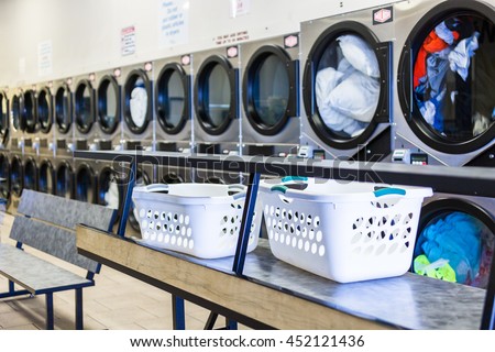 Industrial washing machines in a public laundromat. Royalty-Free Stock Photo #452121436