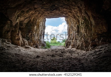 Entrance to an abandoned karst cave closeup Royalty-Free Stock Photo #452129341