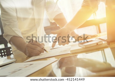 Team work success.business managers working with new startup project in modern office.Businessman adviser analyzing financial figures denoting the progress in the work of the company,vintage color Royalty-Free Stock Photo #452141449