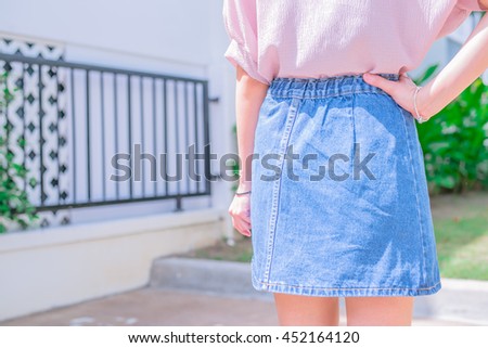Cute teenage girl in casual wear and jean skirt in the park on sunny summer, Thailand, vintage tone.