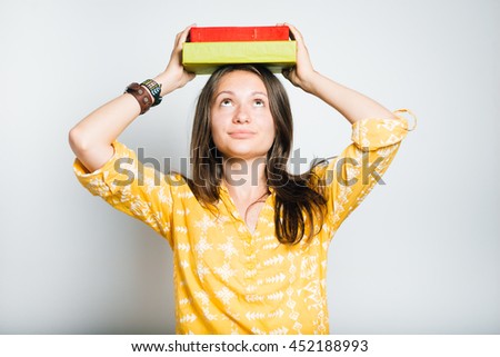 pretty girl student holding books on her head, studio photo, isolated