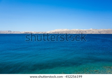 Island Pag and Adriatic Sea in Croatia Europe. Beautiful nature and landscape photo of the ocean in Dalmatia. Warm summer day with nice clear blue sky. Happy and joyful image.