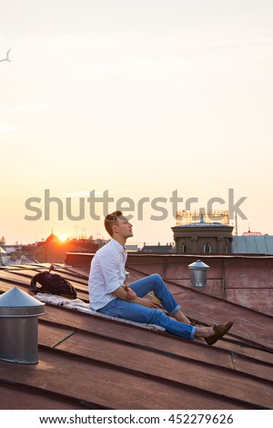 image of young attractive man relaxing on the roof