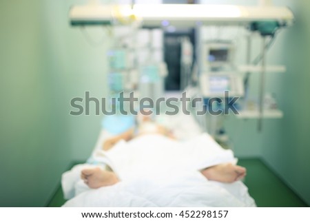 Comatose patient in ICU ward, defocused background.