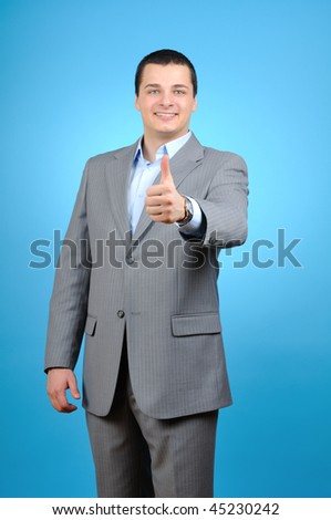 Handsome businessman thumb up on blue background