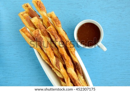 Cinnamon sugar puff pastry sticks with chocolate sauce in a cup