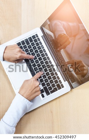 Close-up of hands writing on laptop