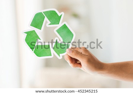 waste recycling, reuse, garbage disposal, environment and ecology concept - close up of hand holding green recycle symbol