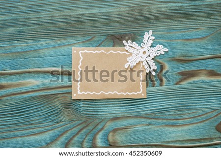 Blank sheet of brown paper with crochet christmas star on wooden background