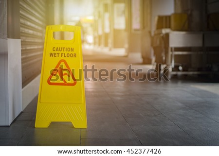 yellow sign inside building hallway,Sign showing warning of caution wet floor,selective focus,vintage color.