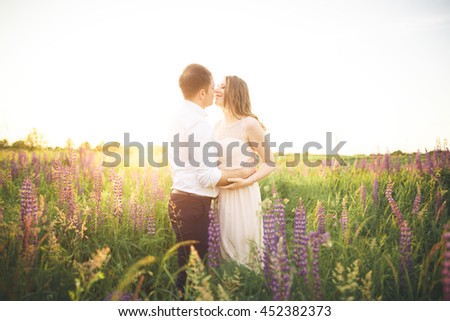 Young wedding couple walking on field with flowers