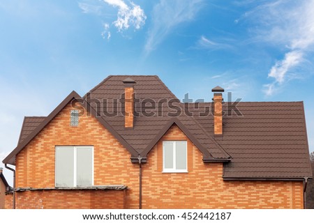 New brick house with modular chimney, Stone Coated Metal Roof Tile, plastic windows and rain gutter Royalty-Free Stock Photo #452442187