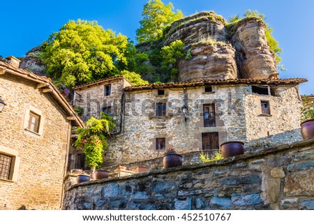 Old houses under the big stones, in Rupit (Catalonia, Spain). Royalty-Free Stock Photo #452510767