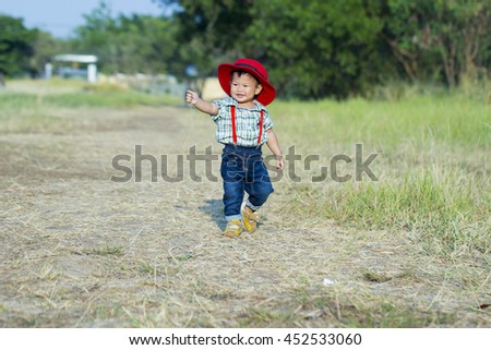 Boy holding an ice cream shaped melons grown in vast grassland with sun light. 