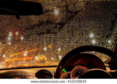 Inside car with bokeh lights from traffic jam on night time for background.