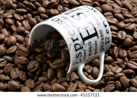 Coffee cup buried in coffee beans
