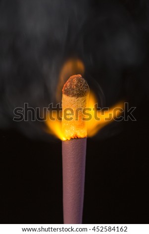 big burning match closeup on a black background