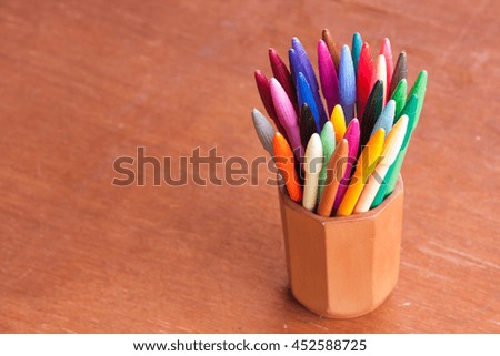 Many colorful pottery pens placed on a wooden floor.