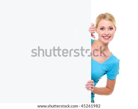 The young beautiful smiling woman looks out because of an empty white advertising banner