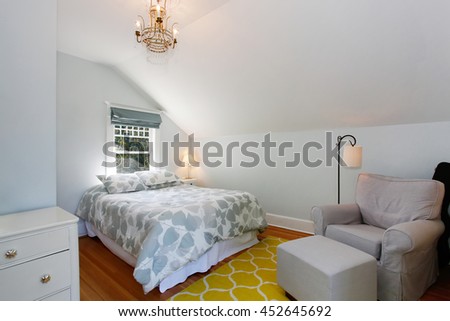 Cozy attic bedroom with white walls and yellow rug.