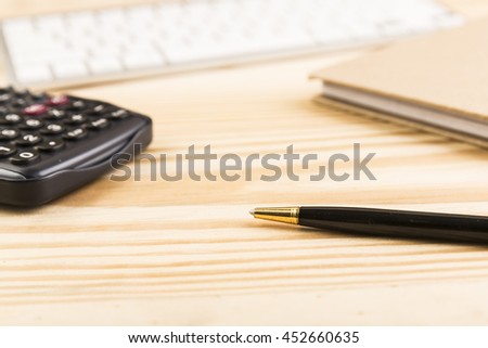 Office table with pen and keyboard and calculator