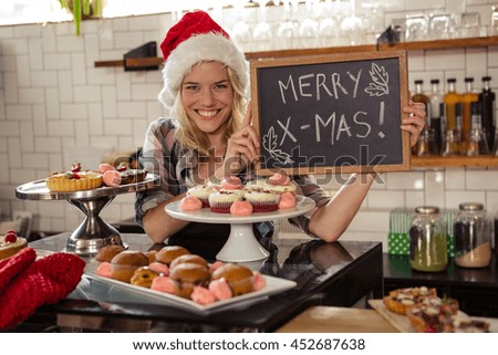 Woman holding blackboard with merry christmas in the cafe