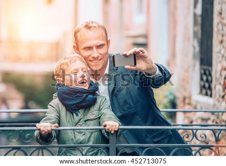 Touristic selfie - father and son take a picture with a smartphone